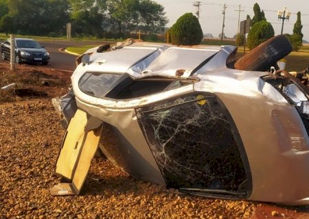 Motorista rampa canteiro, destrói cerca e tomba veículo em rotatória de Fátima do Sul.