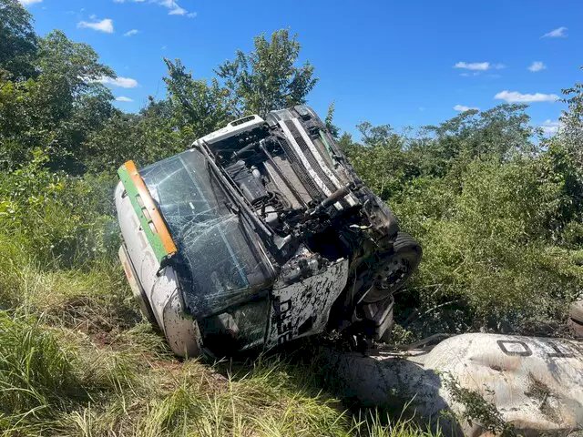 Condutor dorme, mas escapa ileso após tombar carreta carregada de cimento.
