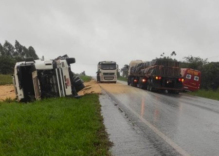 Deodápolis - Carreta tomba e carga de soja fica espalhada na pista na BR 376
