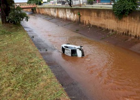 Carro fica destruído ao cair em córrego e três pessoas são socorridas